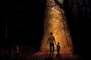 Vater und Kind gehen durch einen Wald