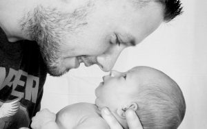 Vater hält sein Baby im Arm und schaut es an