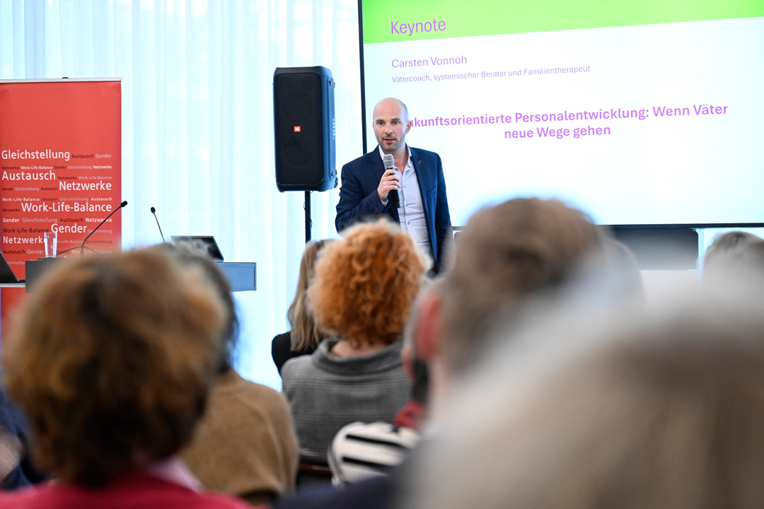 Carsten Vonnoh spricht auf der Bühne, im Vordergrund das Publikum