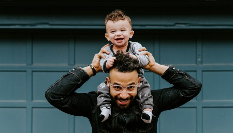 Vater trägt sein Baby auf den Schultern