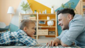Vater und Sohn sitzen auf dem Boden und sehen sich an