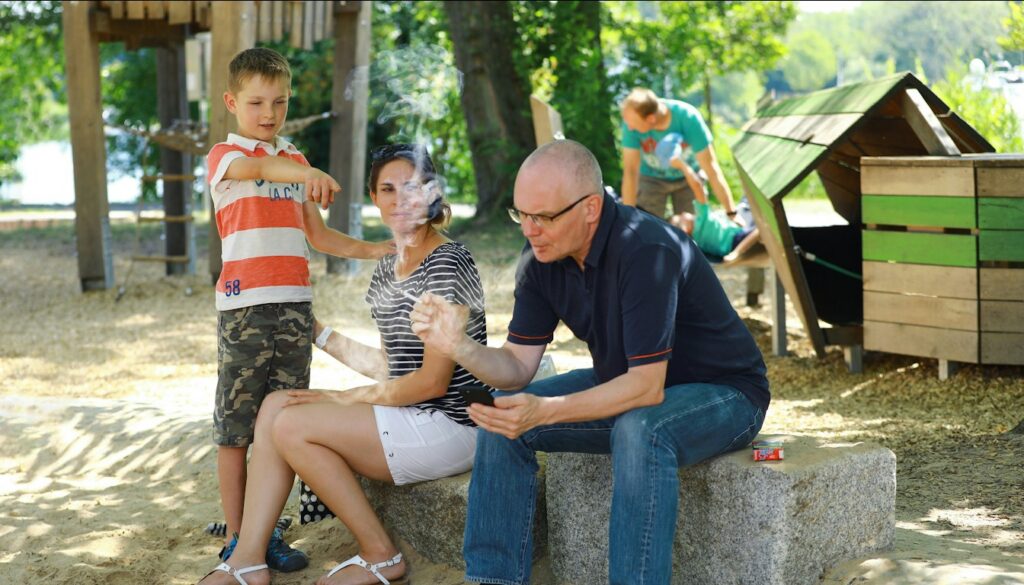 Vater und kleiner Sohn sitzen nebeneinander auf einer Mauer